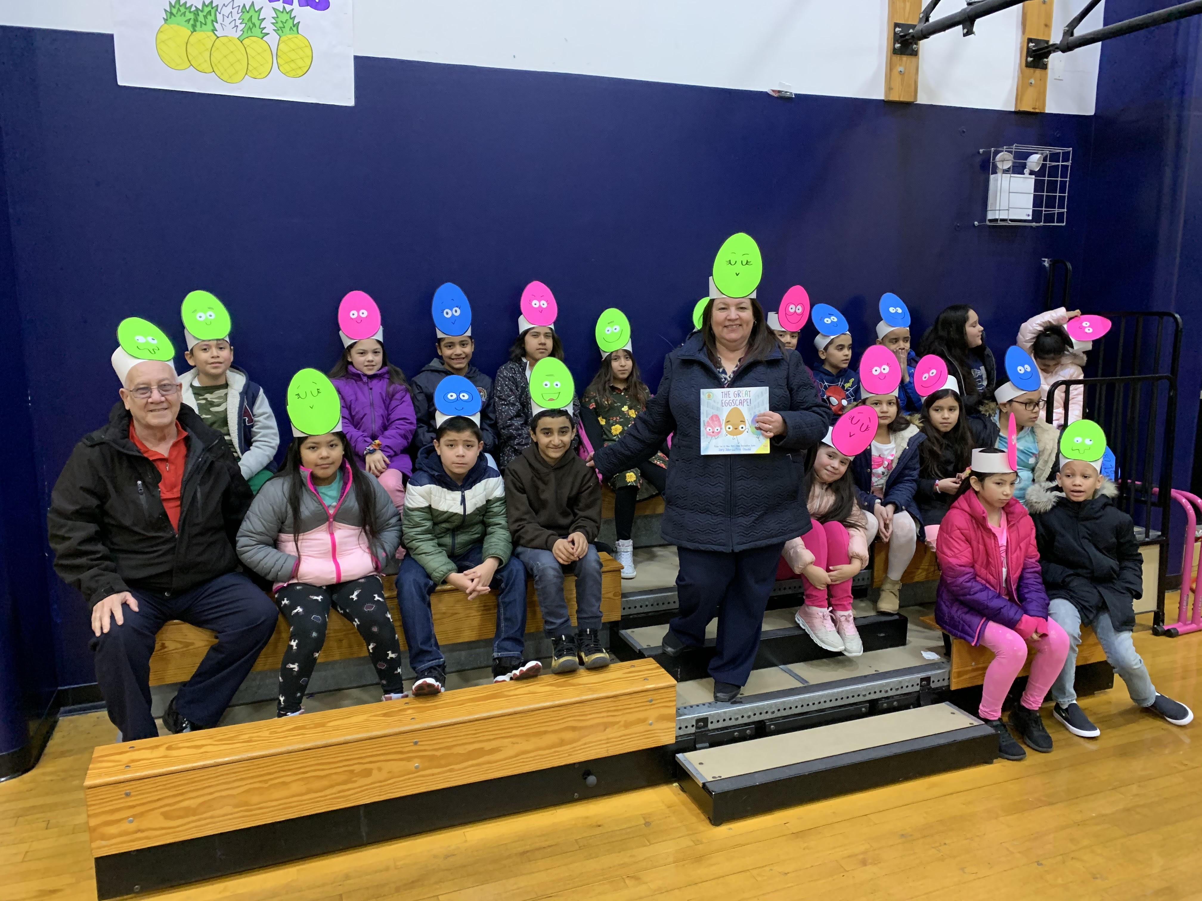 teacher with class wearing large egg hats like their book the great egg escqape